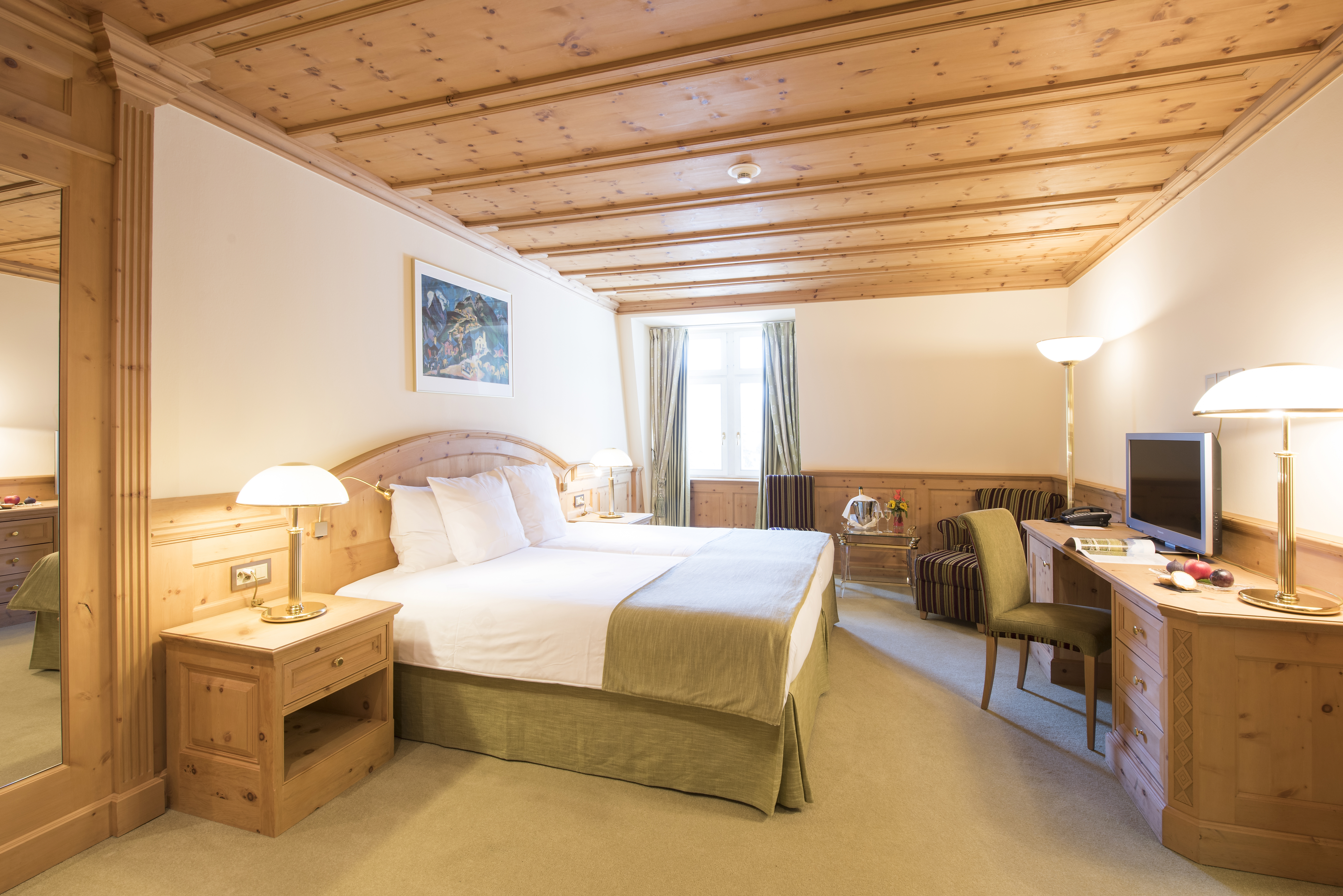 Hotelzimmer mit Doppelbett und schöner Holzdecke